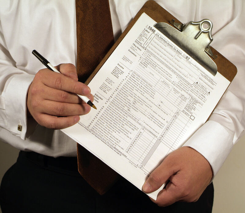 Tax forms and government paperwork spread across a desk