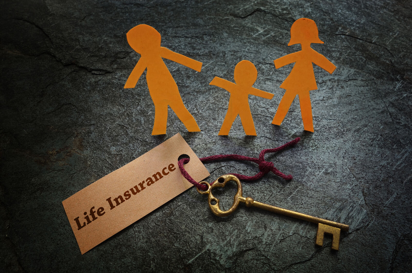 A family protected under a paper cutout representing life insurance coverage